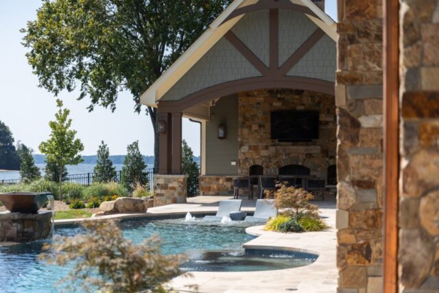 In ground pool with covered pavilion and reclaimed hand hewn fireplace mantel